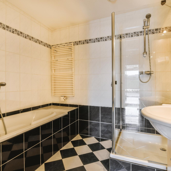 Bathroom tile upgrade with black and white wall tiles and modern shower enclosure