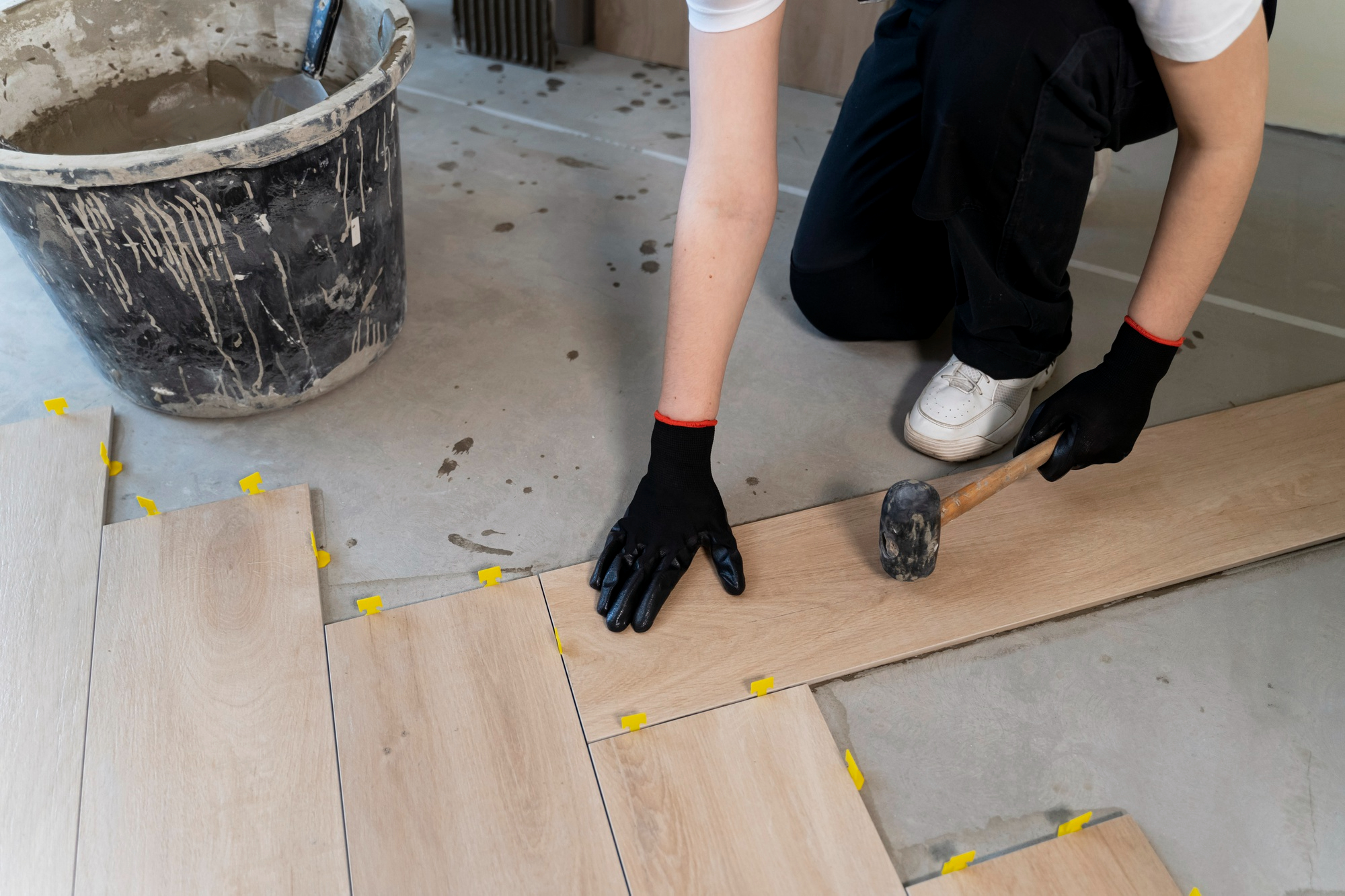 A worker carefully placing wooden planks during a home renovation project.