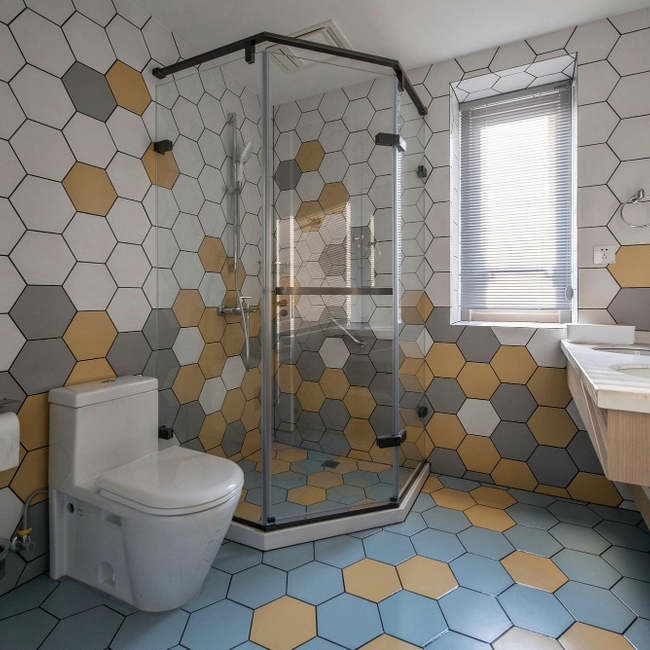Hexagon bathroom tile installation with modern shower enclosure