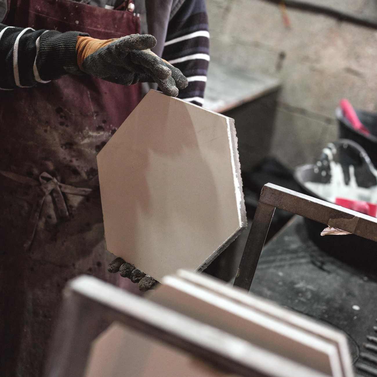 Worker preparing hexagon ceramic tile for installation